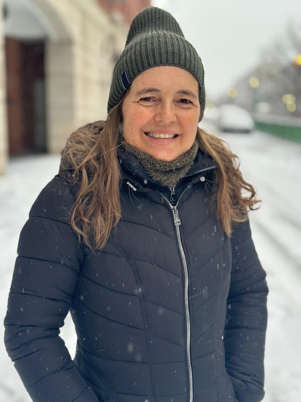 Georgina Elustondo sonríe en una calle nevada, con gorro de lana y abrigo oscuro